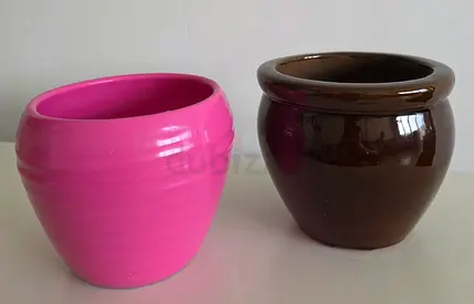 Two ceramic plant pots — pink and brown