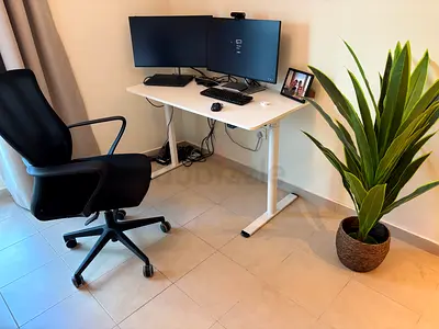 Height-adjustable white standing desk with chair