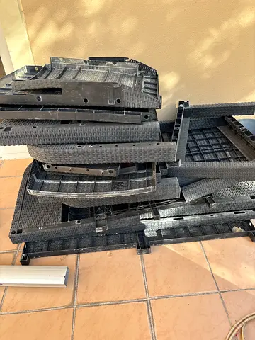 Stack of Black Rattan-Style Outdoor Patio Chairs (Disassembled/Parts)