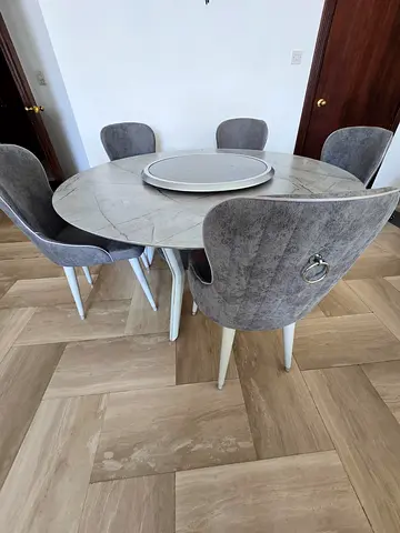 Round marble-look dining table with 6 grey chairs
