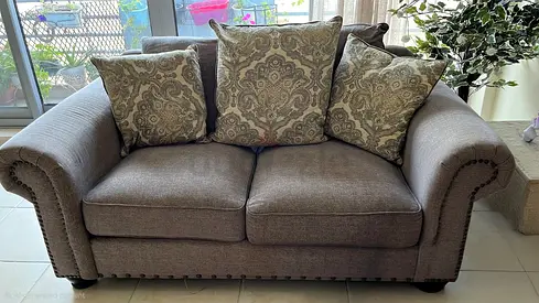 2-seater fabric sofa with patterned cushions — good condition