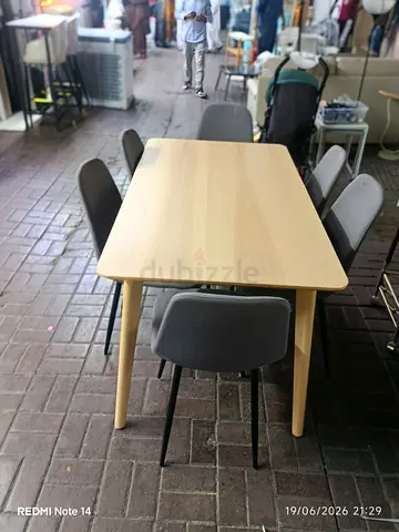 Light wood dining table with 6 grey chairs