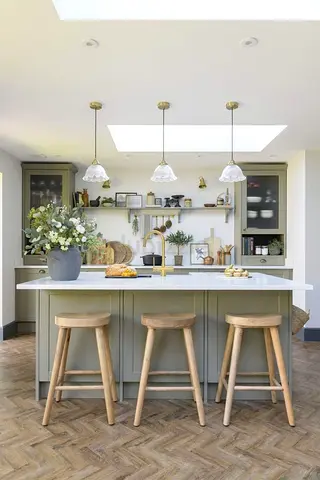Modern kitchen island with three wooden stools and pendant lights