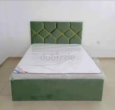 Green upholstered double bed with storage base and geometric headboard