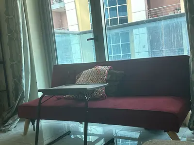 Compact maroon sofa bed with wooden legs - good condition