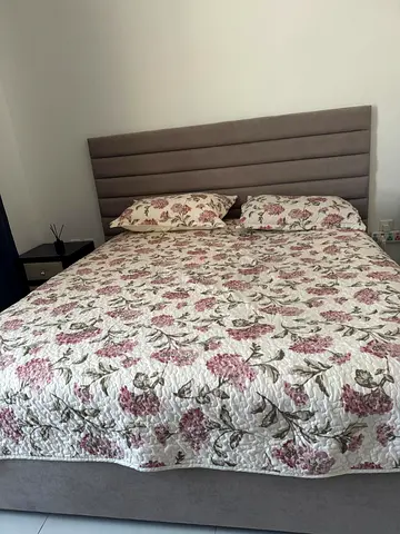 Queen upholstered bed frame with padded headboard and bedside table