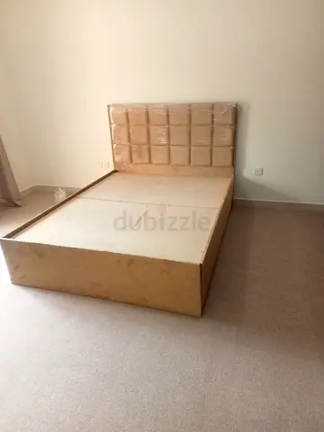 Beige double bed frame with padded headboard