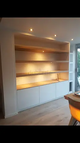 Built-in wall shelving unit with cabinets and integrated lighting