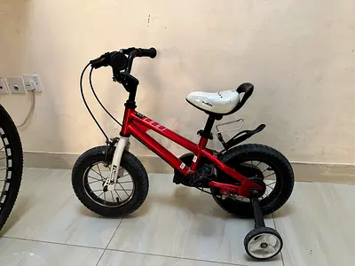 Red kids bicycle with training wheels - good condition