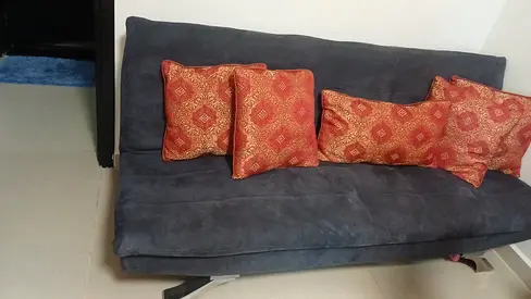Dark grey convertible sofa bed with cushions