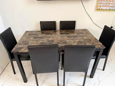 Marble-top dining table with 6 black leather chairs