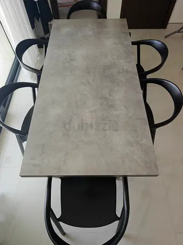 Modern concrete-look dining table with 6 black wooden chairs
