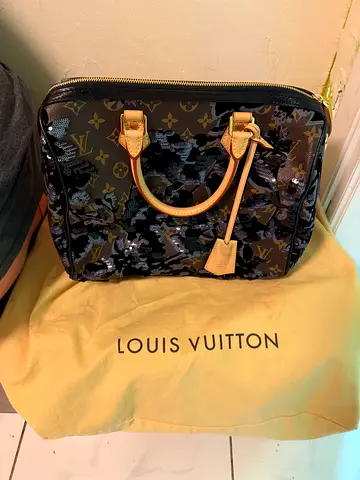 This Louis Vuitton Speedy bag features a unique black and sequined floral camouflage design.
