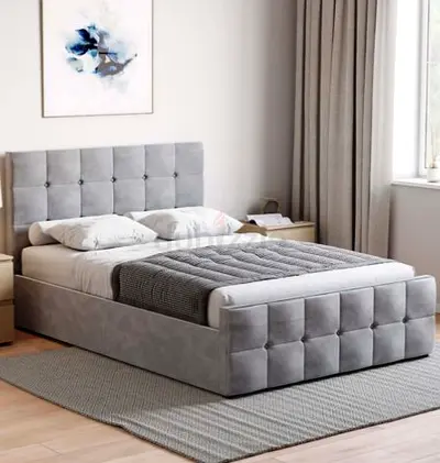 Grey upholstered double bed frame with tufted headboard and storage-style base