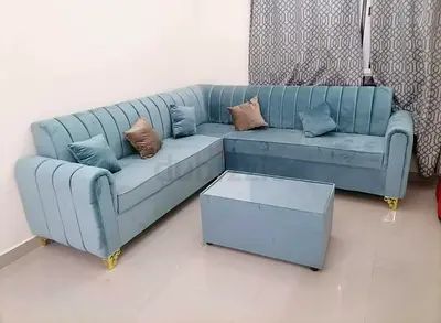 Light blue L-shaped velvet corner sofa with matching coffee table