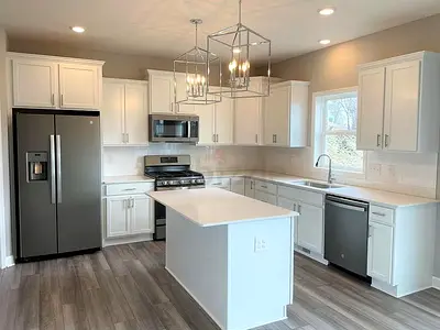 Modern white fitted kitchen with island and storage cabinet