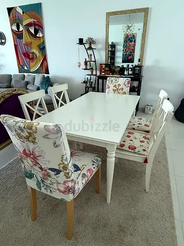 White extendable wooden dining table with 6 floral chairs - good condition