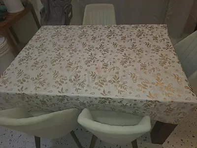Dining table with 4 upholstered chairs and tablecloth - good condition