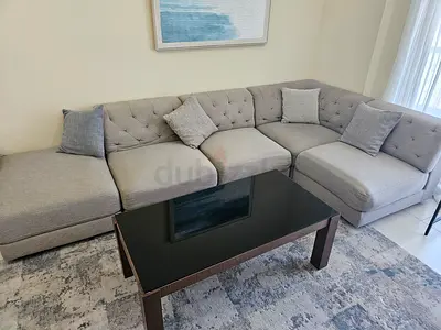 Light grey L-shaped fabric sectional sofa with cushions