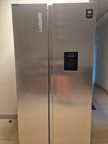 Side-by-side stainless steel refrigerator with water dispenser - good condition