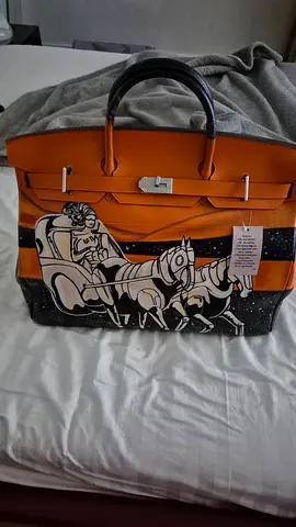 Orange leather tote bag with black illustrated panel