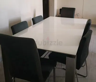 White glass dining table with 6 upholstered chairs - good condition