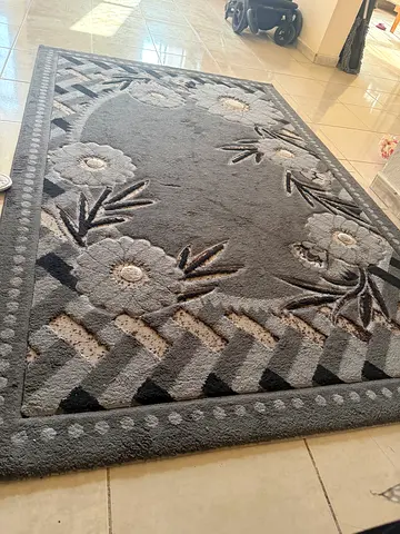 Grey floral patterned area rug — good condition