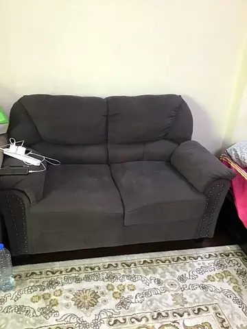 Two-seater grey fabric reclining loveseat with studs