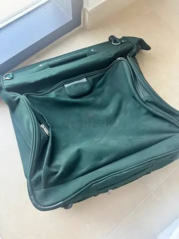 Dark green soft-sided duffel suits bag carry on