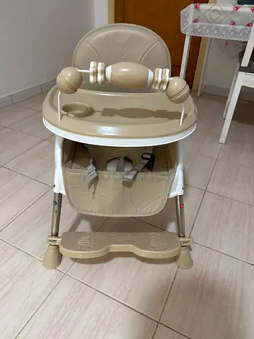 Foldable beige baby high chair with tray and footrest