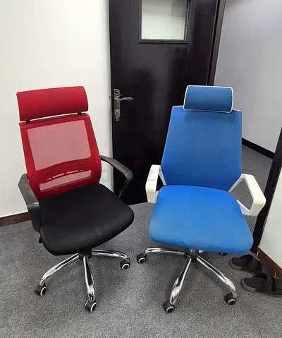 Two ergonomic office chairs — red mesh and blue fabric, good condition