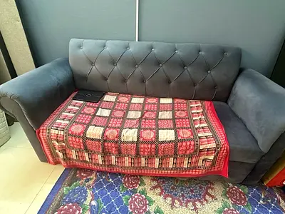 Two-seater grey velvet sofa in good condition