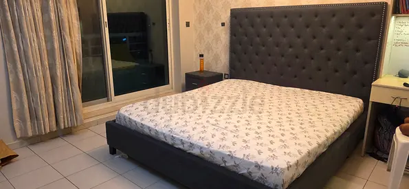 Dark grey upholstered king bed frame with tufted headboard side table and mattress