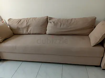 Large beige three seater fabric sofa