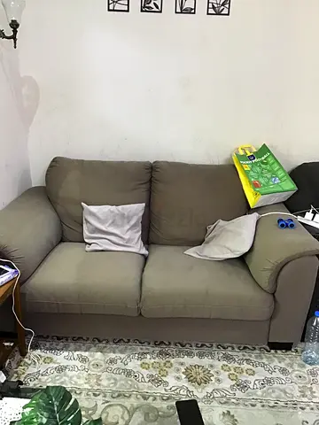 Two-seater beige fabric sofa in good used condition