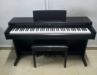 The Yamaha YDP-165R is a premium, full-sized 88-key digital console piano in a matte dark rosewood