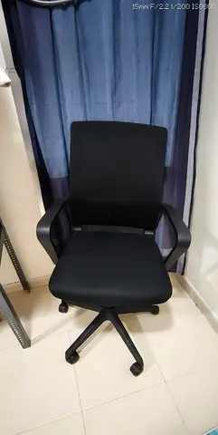 Black ergonomic office chair with armrests and wheels