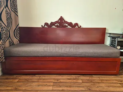 Solid wood daybed with decorative backrest and mattress and storage under the seat.