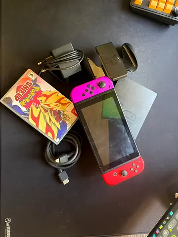 Nintendo Switch console with Joy‑Cons, dock, charger and Pokémon Shield and smash bros