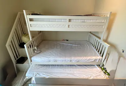 White wooden triple bunk bed with pull-out trundle — good condition