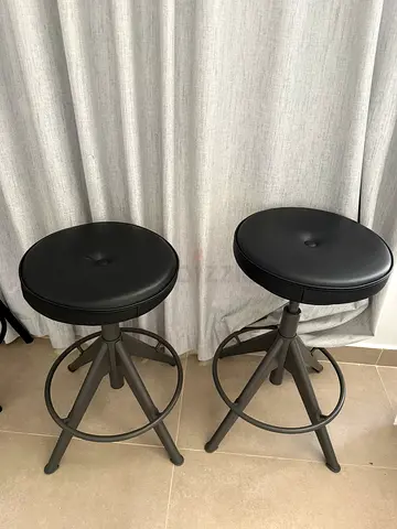 Pair of adjustable metal bar stools with black padded seats