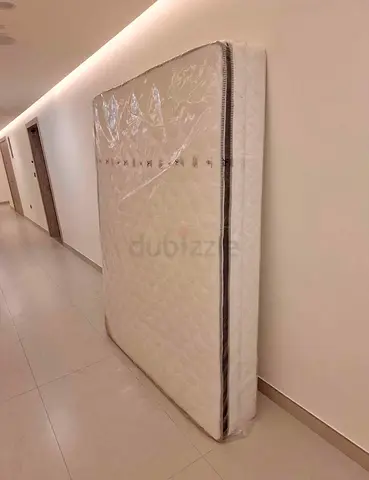 Almost-new queen mattress wrapped in plastic