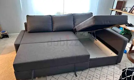 Dark grey L-shaped sofa bed with storage — good condition
