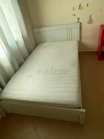 Single white wooden bed frame with mattress