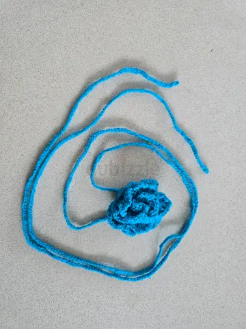 Handmade knitted blue flower hair accessory with long tie