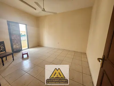 The apartment features a balcony, closed kitchen, central air conditioning, and free maintenance, located just minutes from Ajman Corniche.