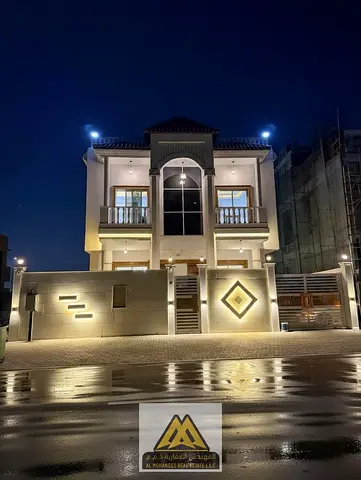 offering a practical layout ideal for large families. The villa includes 4 bedrooms, a majlis, two living rooms, two kitchens, an outdoor seating area
