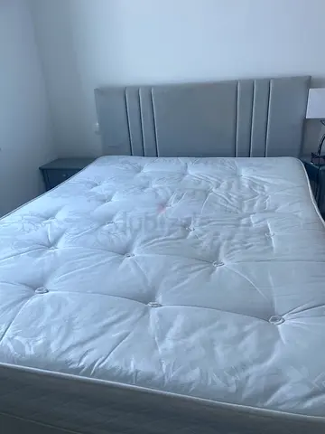 King bed frame with mattress and light grey headboard