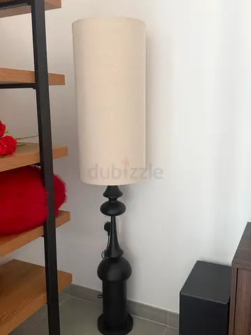 Tall black metal floor lamp with beige fabric shade