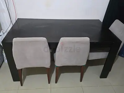 Solid dark wood dining table with two upholstered chairs - used